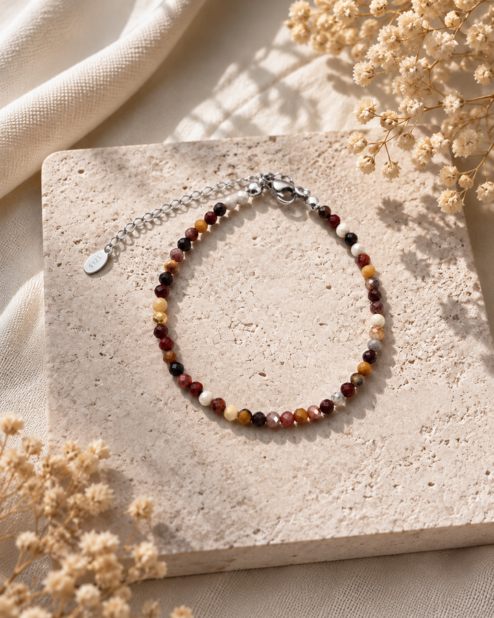 Eleganta dabīgā mokaita rokassprādze ar smalkām 3 mm slīpētām pērlītēm brūnos, bordo, dzeltenos un krēmkrāsas toņos, sudraba aizdari un regulējamu ķēdīti uz gaiša dabīgā akmens fona