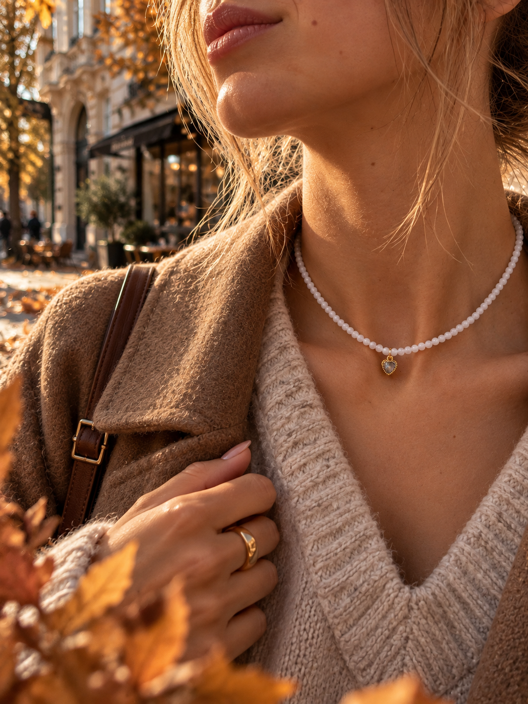 Mēnessakmens kaklarota ar zeltītu sirds piekariņu uz modeles kakla, papildinot elegantu rudens stila apģērbu – Secret Stones.