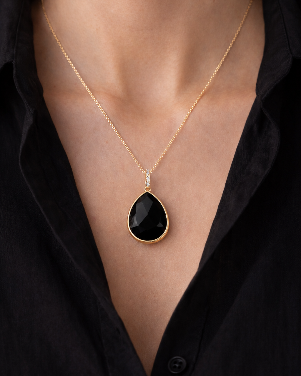 Eleganta zelta kaklarota ar dabīgā melnā obsidiāna kulonu piliena formā. Minimālistisks un grezns dizains uz smalkas zelta ķēdītes.