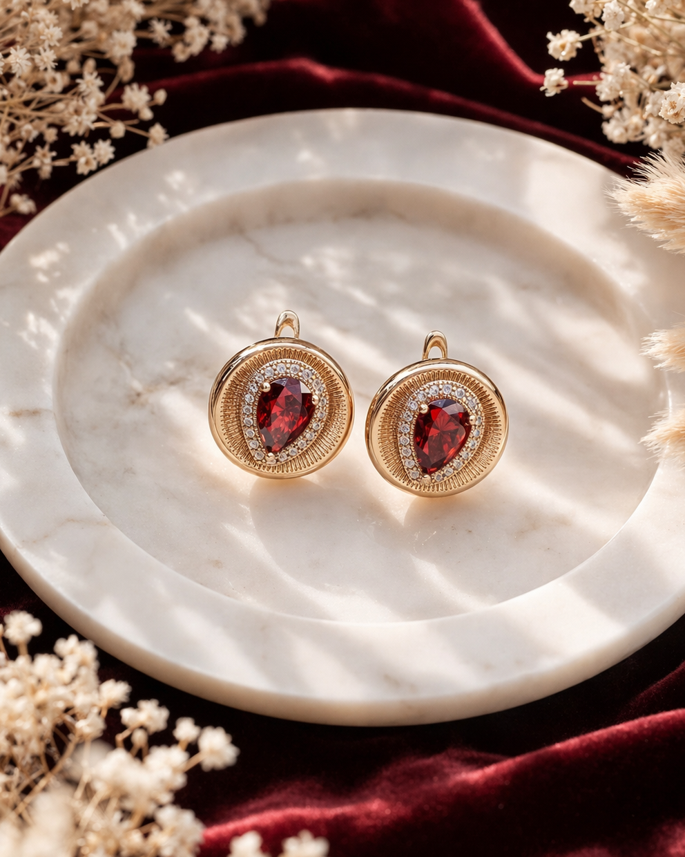 auskari ar sarkanu kristālu lāsītes forma apaie ausakri sapzeltīti