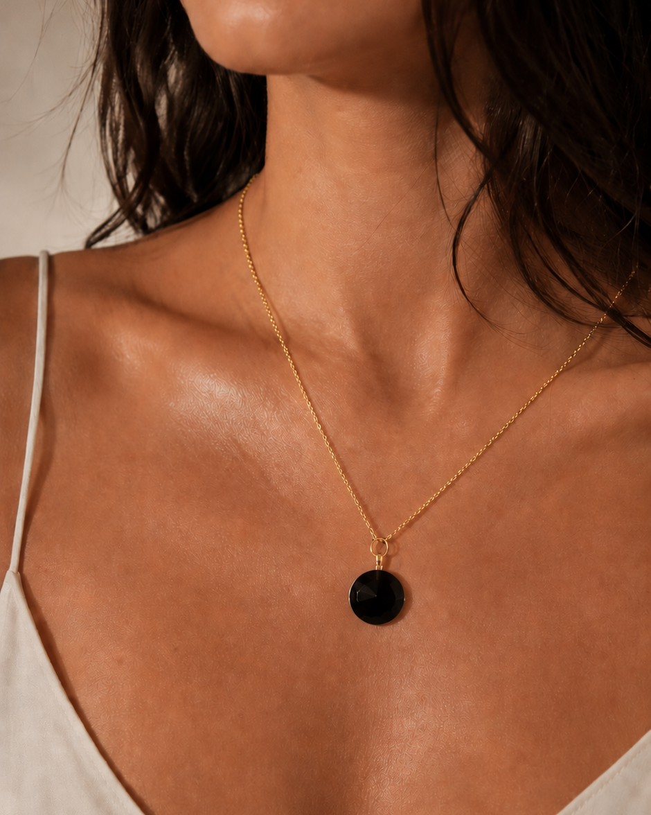 Eleganta melna obsidiāna aromterapijas kaklarota ar apaļu atveramu kulonu-pudelīti uz smalkas zelta krāsas ķēdītes. Kulons paredzēts ēterisko eļļu vai smaržu iepildīšanai un simbolizē aizsardzību, spēku un stabilitāti.
