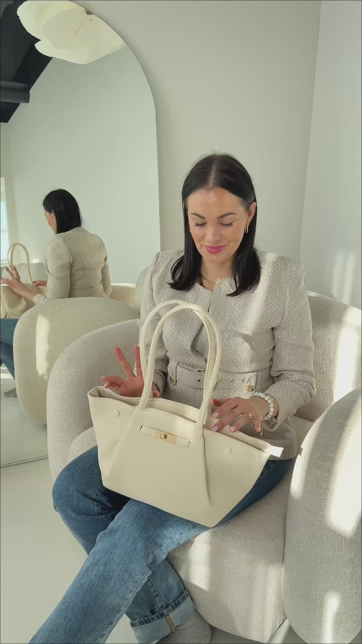 Video ar elegantu sieviešu somu no mākslīgās ādas, kas parāda somas ietilpību, dizainu un detaļas dabīgā apgaismojumā. Ražota Francijā, ideāli piemērota ikdienai, darbam un ceļojumiem.