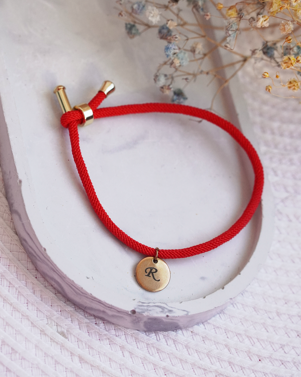 Sarkanais diegs ar medaljonu aizsardzībai